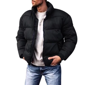 Detail of black puffer jacket showing stand-up collar and circular emblem on sleeve