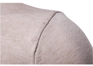 Dettaglio macro della cucitura della spalla di un maglione beige slim fit