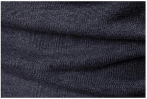 Macro di tessuto a maglia fine grigio scuro con pieghe morbide e trama ad alta densità
