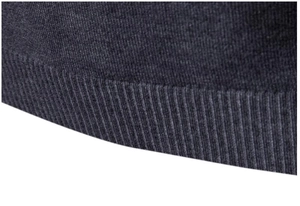 Primo piano dell'orlo in maglia a coste grigio scuro su un maglione da uomo a collo alto
