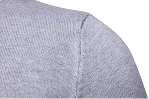 Dettaglio macro della cucitura sulla spalla in maglia fine di un maglione grigio