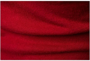 Macro di tessuto a maglia rosso che mostra la consistenza morbida e lo spessore della lana