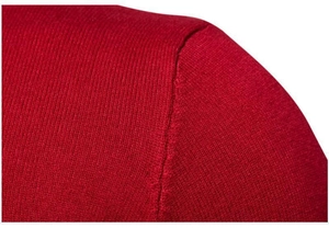 Dettaglio delle cuciture della spalla di un maglione rosso in maglia e trama del tessuto