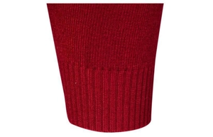 Dettaglio della trama in maglia a coste sul polsino di un maglione a collo alto rosso