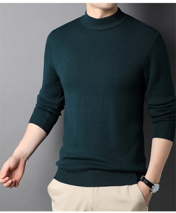 Dettaglio maglione in maglia verde scuro con collo a lupetto, polsini e texture