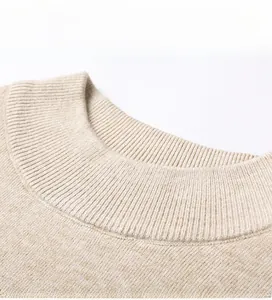 Dettaglio del girocollo a costine e della trama a maglia fine del maglione beige da uomo