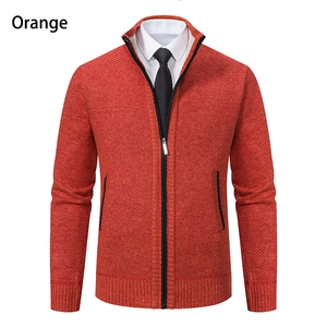 Detail of orange knitted cardigan featuring thick rib-knit texture and stand collar
