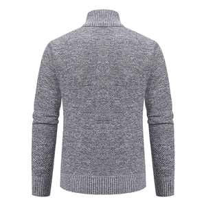Macro shot of the grey knit pattern and ribbed hem on the men's winter cardigan jacket