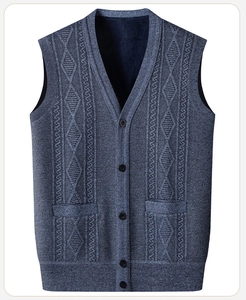 Detail of blue-gray knitted vest showing V-neck, buttons, and cable knit texture