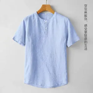 Detalle de camisa de lino azul claro con cuello redondo y tapeta con dos botones