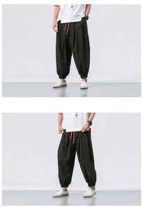 Detail of black cotton linen harem pants featuring contrasting red drawstring and elastic cuffs