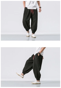 Detail of loose black linen harem pants with red drawstring and elastic cuffs