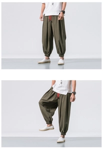 Detail of loose olive green linen harem pants showing elastic cuffs and drawstring