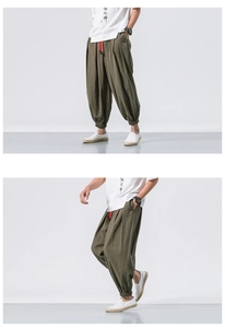 Detail view of olive green linen harem pants with a red drawstring and elastic cuffs