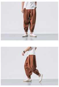 Detail view of brick red linen harem pants featuring drawstring waist and elastic ankle cuffs