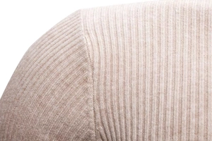Dettaglio macro del maglione a collo alto slim con trama in maglia a coste beige chiaro