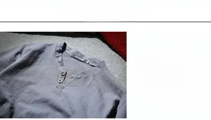 Detail of V-neck cotton linen shirt featuring vintage wooden buttons and textured fabric