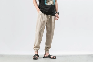 Detailed texture of beige linen drawstring waist and elastic cuffs on men's jogger pants