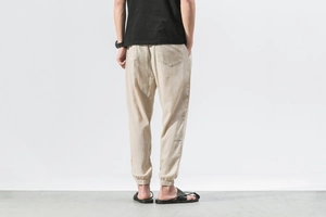 Detail view of beige linen lantern pants with elastic cuffs and a minimalist back pocket