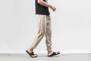Detailed close-up of beige linen harem pants showing elastic drawstring waist and cuffs