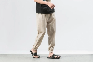 Close-up of linen harem pants with drawstring waist and elastic cuffs in beige tone