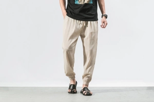 Detail of men's beige linen jogger pants featuring drawstring waist and elastic cuffs