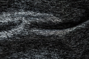 Macro dettaglio del tessuto melange grigio scuro traspirante per maglietta sportiva