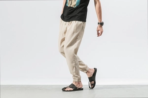 Detail of men's linen jogger pants featuring beige textured fabric and elastic cuffs