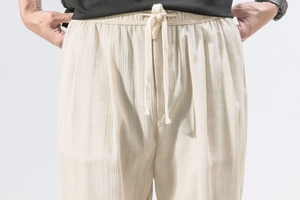 Detail of linen drawstring waist and natural textured fabric on men's harem pants