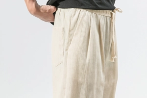 Detail of off-white linen harem pants showing elastic waist, drawstring and vertical texture