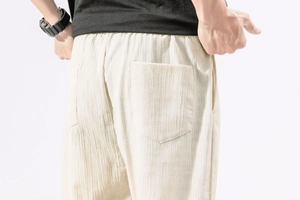 Close-up of the back pockets and textured cotton linen fabric on beige harem pants