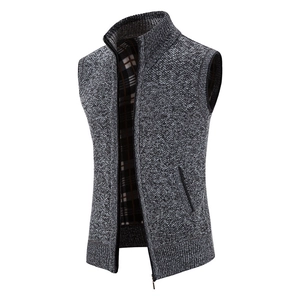 Detail of grey knitted vest showing stand collar, zip closure and plaid lining
