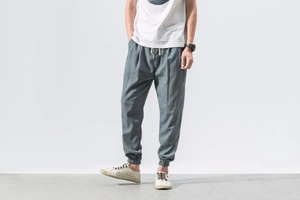 Detail of greyish blue linen harem pants featuring drawstring waist and elastic cuffs