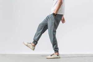 Detail of blue-grey cotton linen joggers showing elastic cuffs and fabric texture