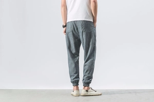Detail view of men's linen harem pants in grey-blue with elastic cuffs and rear pockets