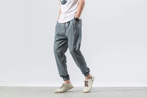 Detail of grey-blue linen harem pants for men showing loose fit and drawstrings