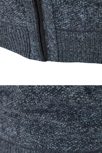 Detail of grey knitted sweater vest featuring metal zipper and ribbed hem texture