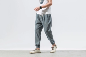 Detail of grey-blue linen joggers featuring adjustable drawstring waist and elastic cuffs