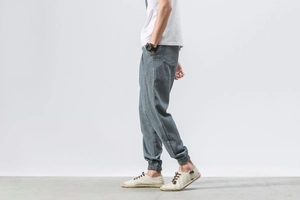 Detail view of grey linen texture fabric and elastic cuffs on men lantern trousers