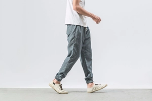 Detail view of men's linen jogger pants in grey with elastic cuffs and side pockets