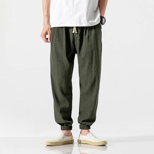 Detailed shot of olive green linen harem pants showing drawstring waist and elastic cuffs
