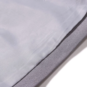 Detailed macro view of the grey suit fabric texture and durable woven trim reinforcement