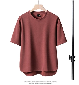 Detail view of brick red t-shirt with CORDURA fabric label and curved hemline