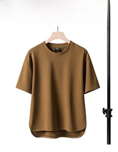 Detail of loose-fit brown T-shirt with irregular curved hem and premium pique fabric