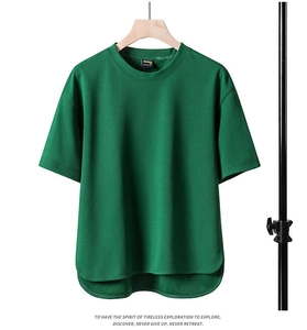 Detail of dark green crew neck T-shirt featuring CORDURA fabric label and curved hemline