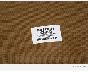 Detail view of the vintage white fabric label sewn on breathable brown pique cotton fabric