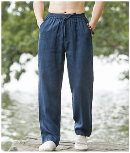 Detail of dark blue linen pants featuring elastic drawstring waist and breathable texture