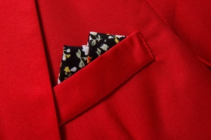 Detail of red slim fit suit jacket chest pocket with floral pattern pocket square