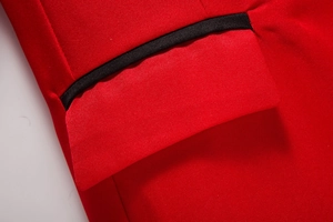 Detail of red blazer pocket with black trim showing fabric texture and stitching
