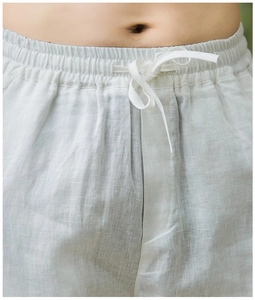 Close-up of elastic waistband with drawstring on white linen trousers for men